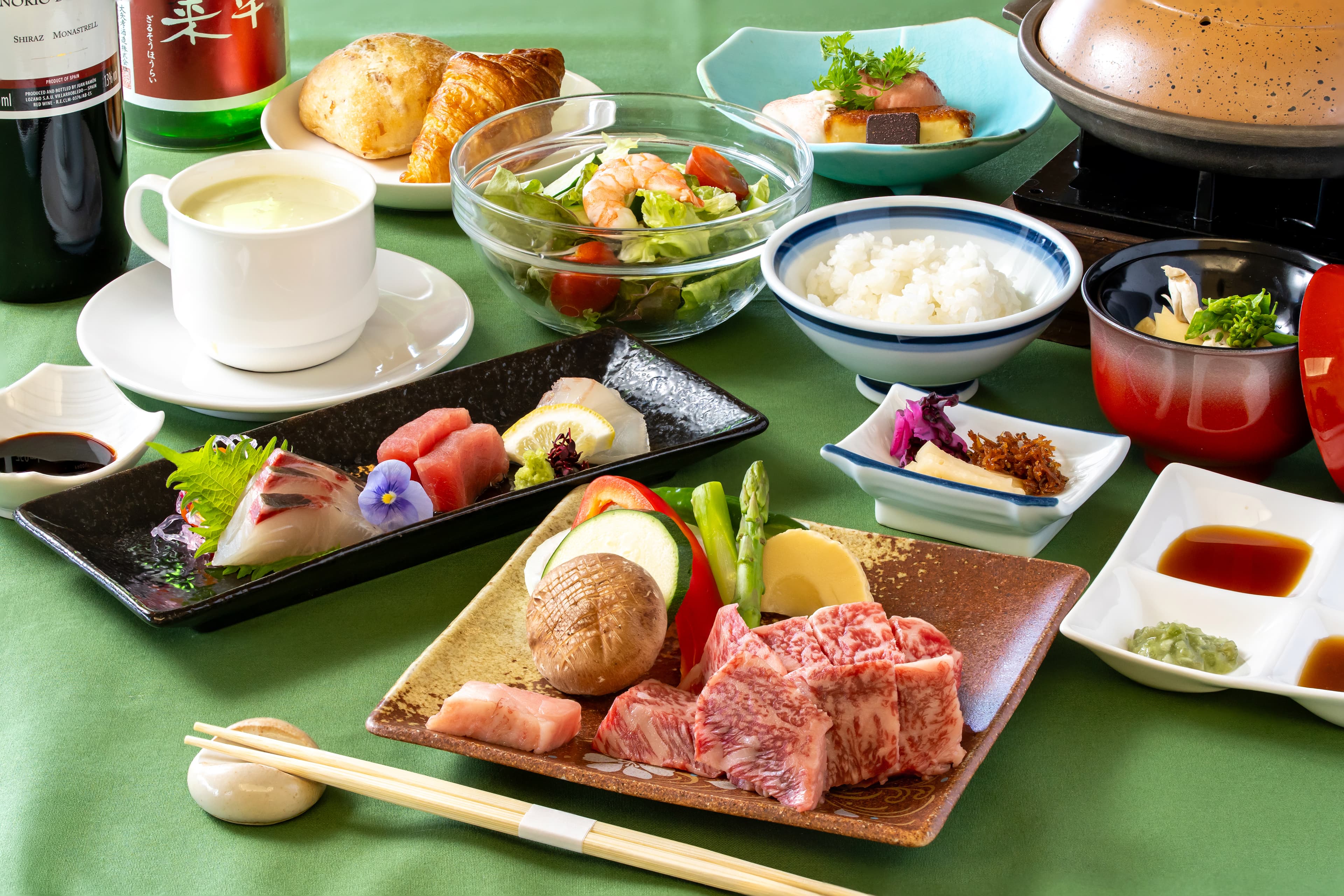 強羅荘のステーキコースの膳。和牛サーロインの角切りと鉄板用の野菜、造り、サラダ、パンとスープ、副菜、甘味までがテーブルに並んだ様子。